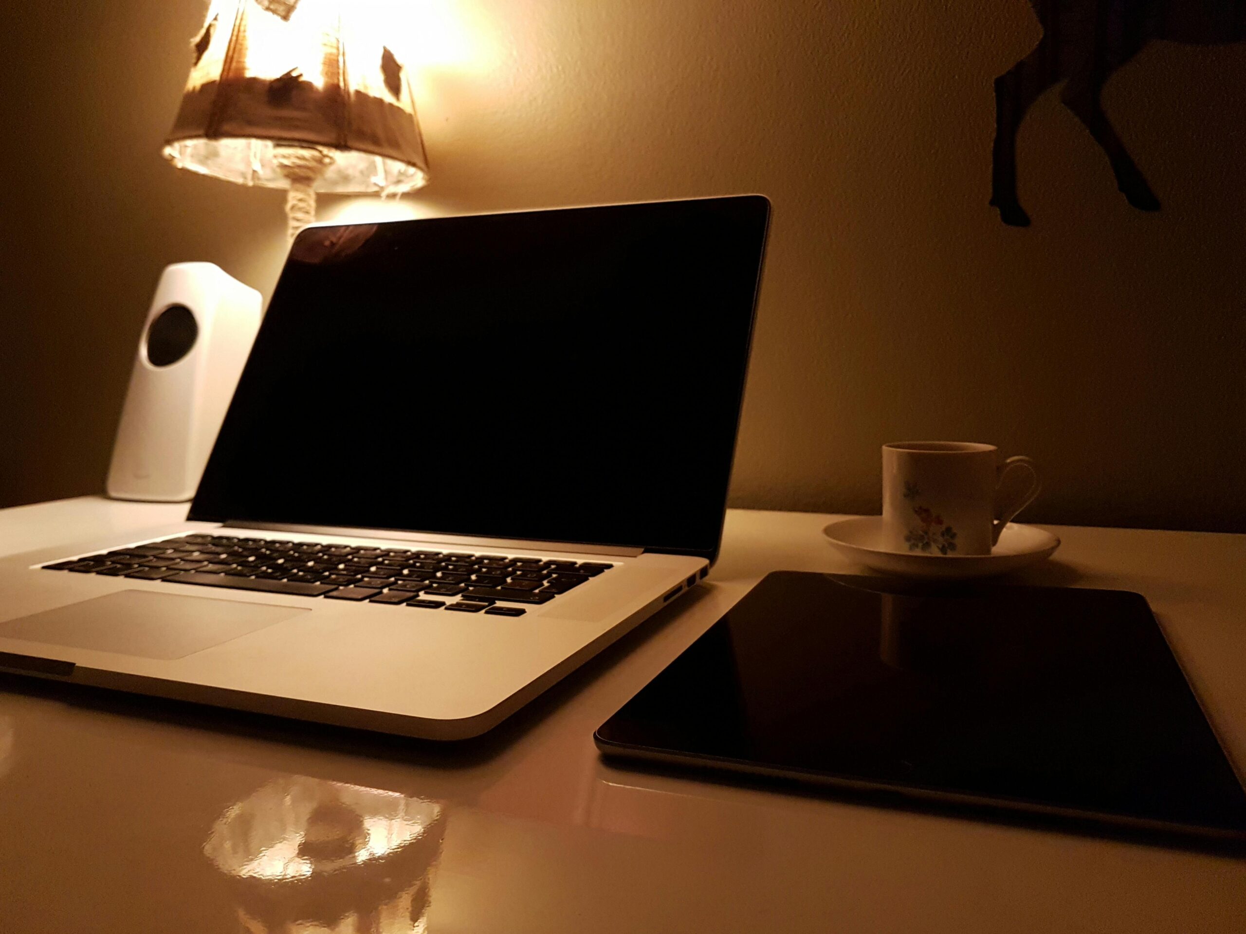 Silver and black laptop with soft lamp lighting.
